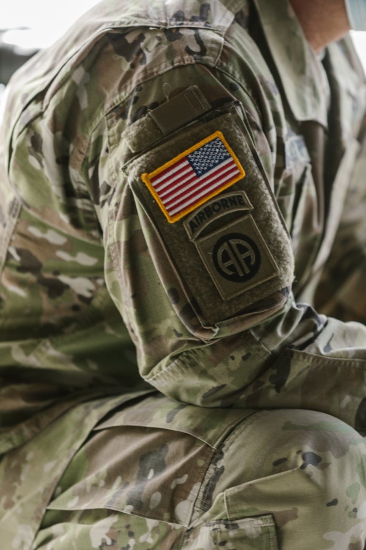 Close-up of a U.S. Army uniform sleeve with American flag and Airborne patches